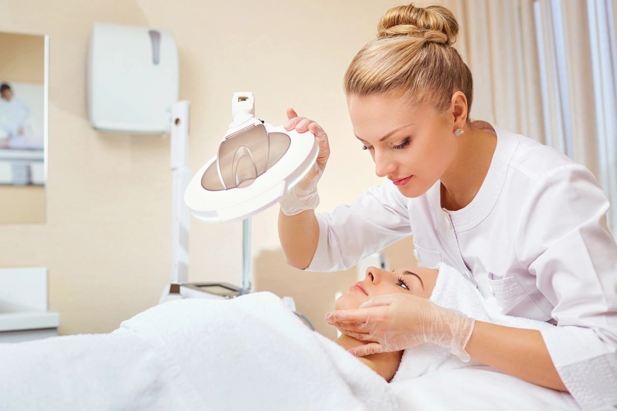 Beautician examining client's skin.